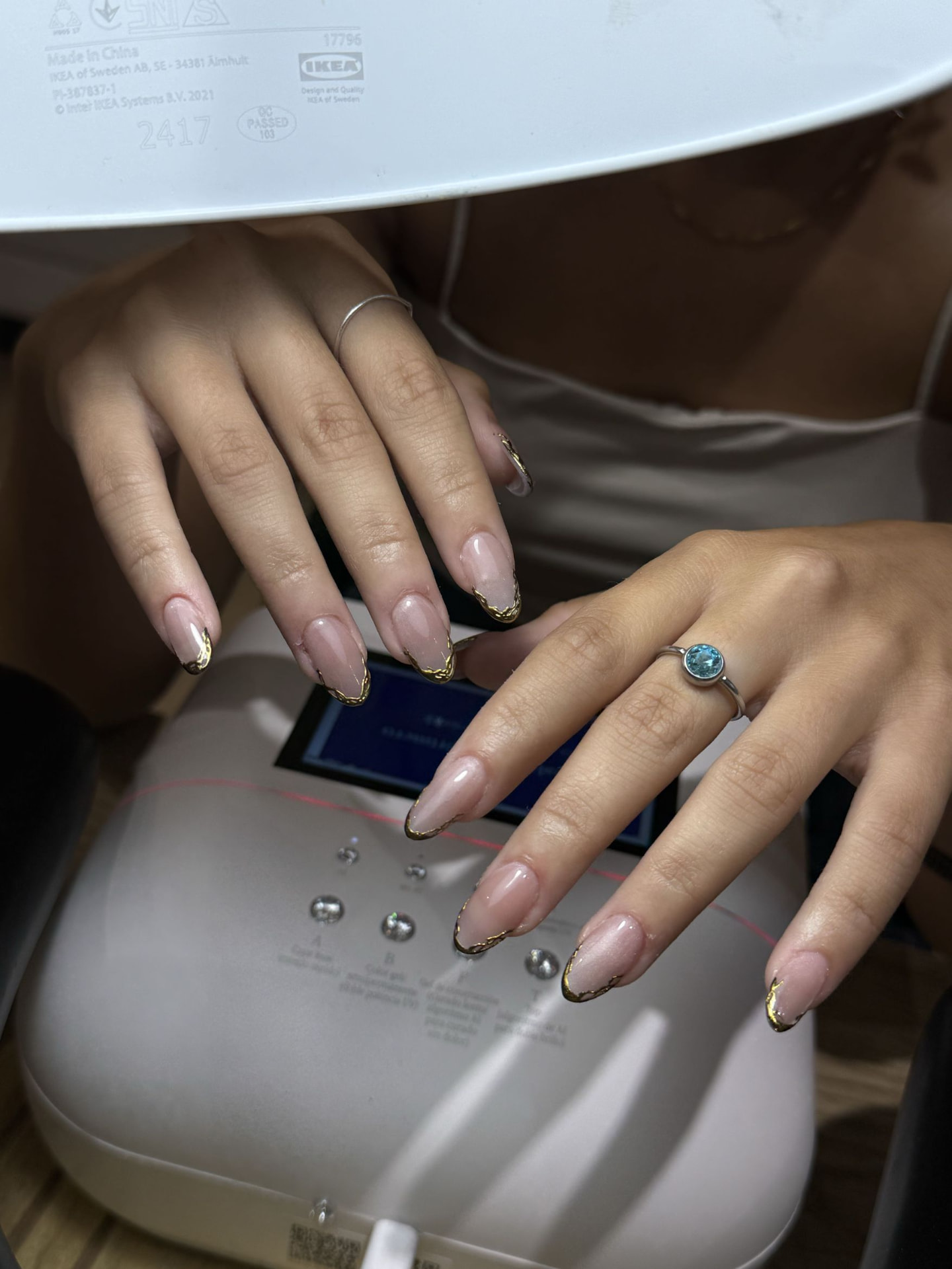 Uñas almendra nude con bordes dorados